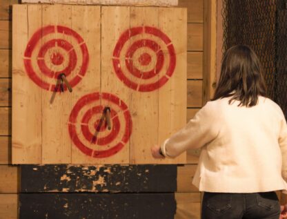 Adult throwing axe to three spot target